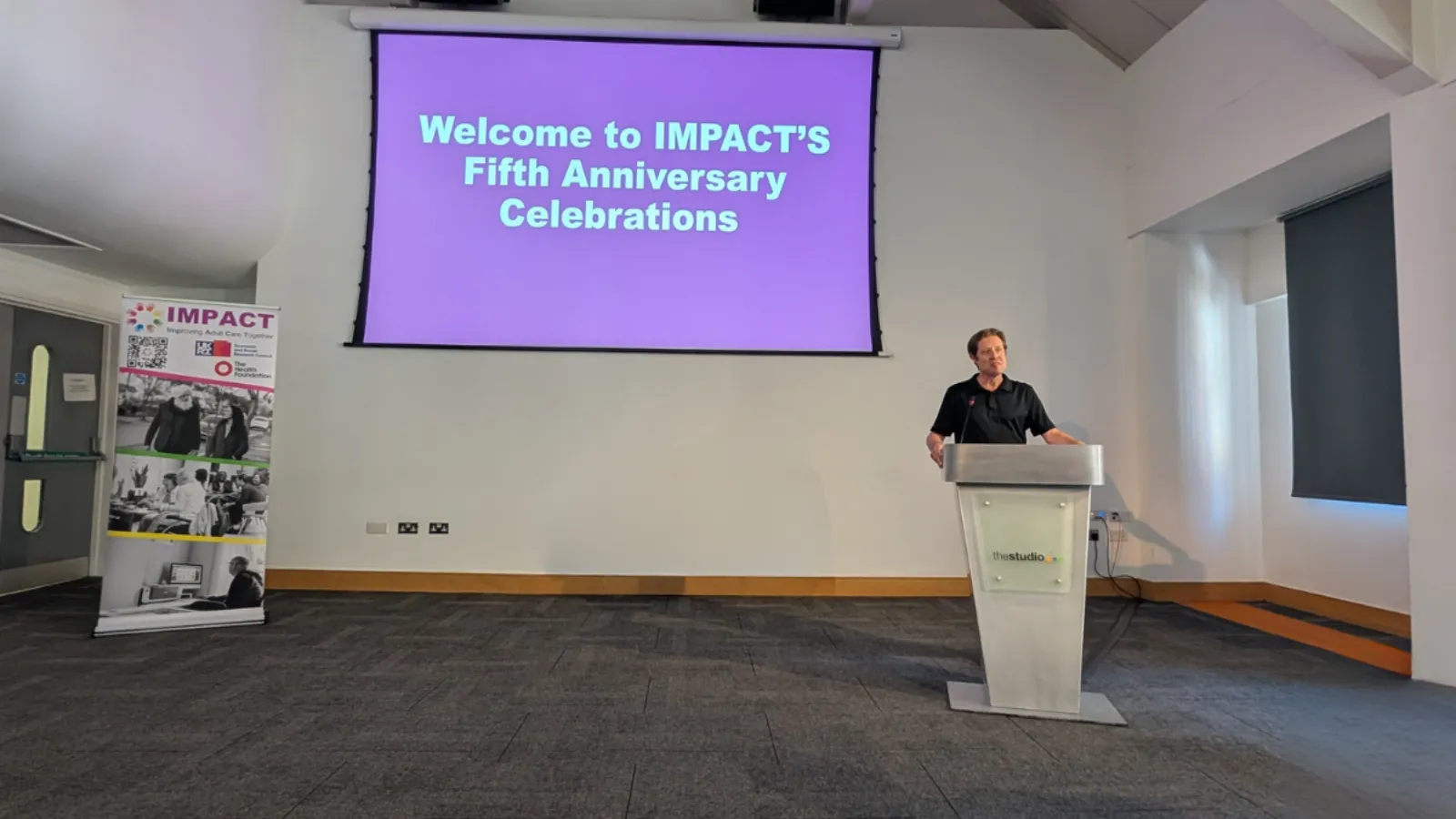 Jon Glasby welcomes people to IMPACT's Fifth Anniversary Showcase event